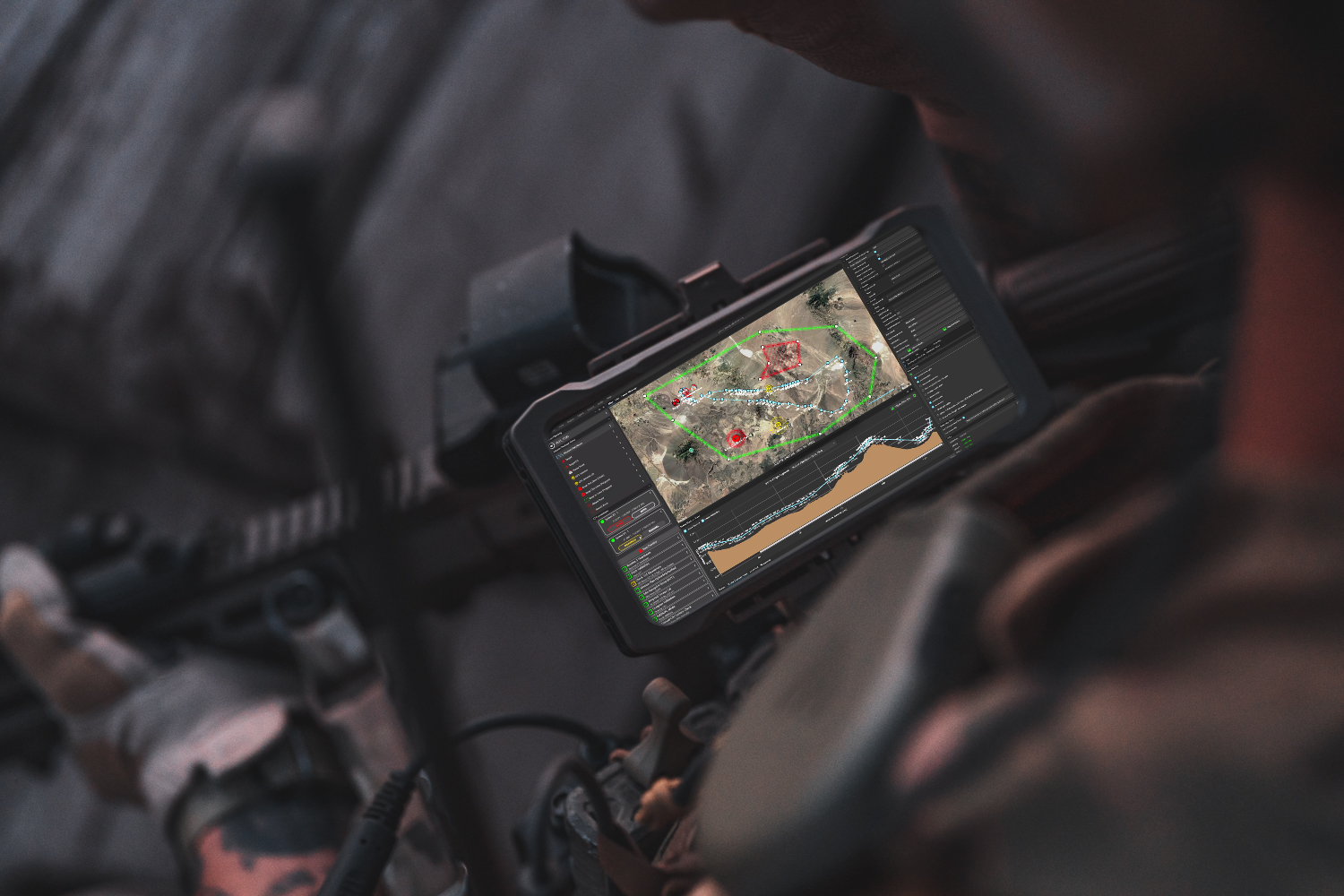 A soldier's weapon-mounted phone running mission-planning software, showing a route and keep-out zones over desert terrain